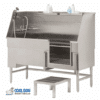 A stainless steel dog washing tub with a faucet, sprayer hose, shampoo bottles on a shelf, and a small step stool in front. The tub has a front opening and is elevated on metal legs. Logo: "Cool Dog Wash Tubs.