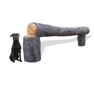 A black dog sits next to a bench designed to look like a large, textured log supported by two smaller log-shaped bases. The bench and dog are on a plain white background.