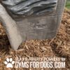 Close-up of a textured, gray structure set in mulch, with the embossed text "COOL DOG MADE" and the words “Play & Agility Powered by GymsForDogs.com” in bold white letters at the bottom.