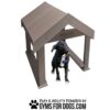 A black dog with a white chest sits under a brown, wooden A-frame agility structure. Text below reads, "Play & Agility Powered by gymsfordogs.com" with a paw print graphic.