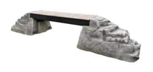 Ellie's Boulder Bridge Pro features a wooden bridge supported by two large gray rock-like structures and bumper pads. Ideal for any dog park or training area, it adds challenge and excitement to outdoor spaces.