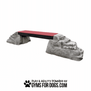 Ellie's Boulder Bridge Pro—featuring a bridge with a red walking surface, two rocky ends, and bumper pads—is shown on a white background. "Play & Agility Powered by GymsForDogs.com" appears below with a dog paw logo.