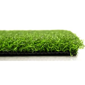 Close-up side view of a rectangular piece of artificial grass turf, showing the green synthetic blades and black backing against a white background.