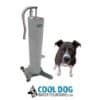 A black and white dog stands next to the Doggie Demand COOL DOG Portable Fresh Flow Water Fountain (silver), which hooks up to a garden hose. Below them is the Cool Dog Water Fountains logo with a dog head graphic and blue text.