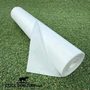 A roll of white fabric or mesh material is partially unrolled on artificial green grass, showing its texture. The "COOLDOG TURF.com" logo with a dog silhouette is in the bottom left corner.